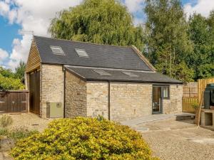 une maison en pierre avec un toit noir dans l'établissement 2 Bed in Glastonbury 88772, à West Pennard