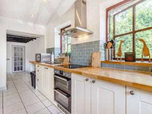 a kitchen with white cabinets and a large window at 2 Bed in Penycae 89170 in Pen-y-cae