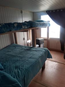 1 dormitorio con 2 literas y ventana en Refugio Jemmy Button en Puerto Williams