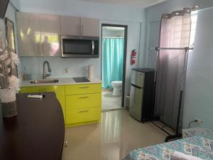 a kitchen with a sink and a yellow cabinet at Studio with private entrance and bath near Beach, Unit 4 in San Juan