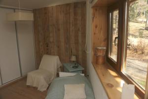 Kleines Zimmer mit einem Bett und einem Fenster in der Unterkunft La casita del Bosque in Trevelín
