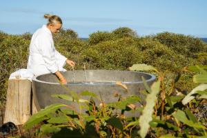 a woman sitting in a bucket of water at Immerse Kangaroo Island in D'Estrees Bay