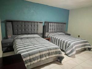 2 camas en un dormitorio con paredes azules en Hidden house, en Ciudad de México