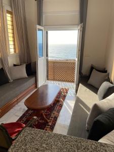 a living room with a table and a view of the ocean at Mirleft Seaside Horizon in Mirleft