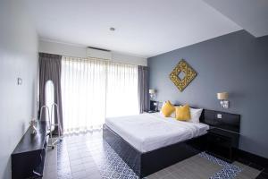 a bedroom with a king sized bed with yellow pillows at 1 BR Serviced Apt In The Heart of Siem Reap in Siem Reap