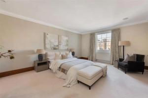 1 dormitorio blanco grande con 1 cama grande y 1 silla en ARCORE Premium Apartments Eaton Place, en Londres
