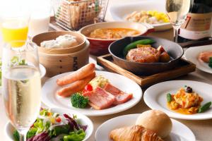 a table filled with plates of food and drinks at Sapporo Excel Hotel Tokyu in Sapporo