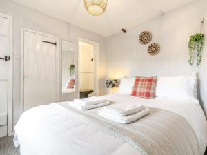 1 Bed in Crackington Haven HAWTH في Saint Gennys: غرفة نوم بسرير ابيض عليها مناشف