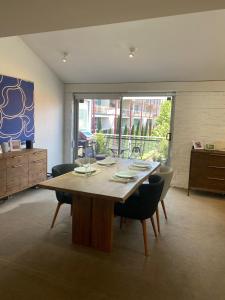 a dining room with a large wooden table and chairs at Boxwood IXL Lux Hobart Waterfront in Hobart