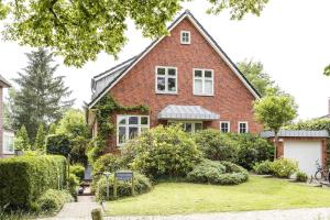 a red brick house with a white garage at Immenhof in Flensburg