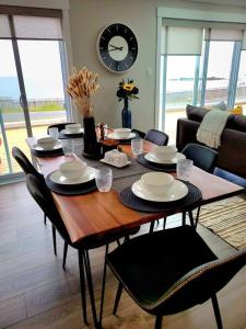 a dining room table with chairs and a clock on the wall at 2 Bedroom 2 Bathroom Oceanfront Oasis in Bonavista
