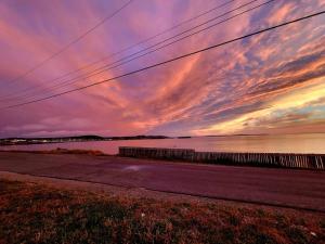 a sunset over a road and a body of water at 2 Bedroom 2 Bathroom Oceanfront Oasis in Bonavista