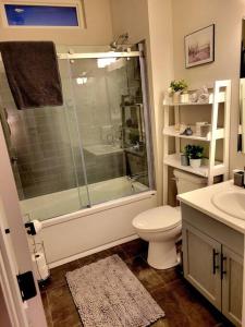 a bathroom with a shower and a toilet and a sink at 2 Bedroom 2 Bathroom Oceanfront Oasis in Bonavista