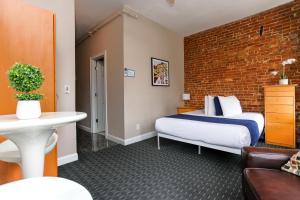 une chambre d'hôtel avec un lit et un mur en briques dans l'établissement Stylish Studio in Boston Brownstone, C.Ave #21, à Boston