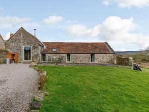 an old stone house with a grass yard at 1 Bed in Wootton Under Edge EARBA in Charfield