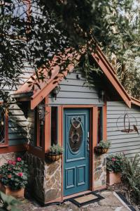 uma pequena casa com uma porta azul e flores em Wild Orchid Olinda Private Luxury Cottage em Olinda
