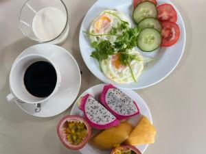 a table with two plates of food and a cup of coffee at Red House Homestay - Villa in Hoi An