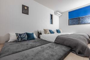 a bedroom with two beds and a couch at エクセルシア in Osaka
