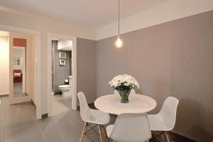 マラガにあるApartamentos Malagueta Urban Beachの花瓶付きのテーブルのあるダイニングルーム +64枚の写真