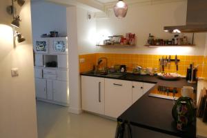une cuisine avec des placards blancs et un comptoir noir dans l'établissement Quiet and spacious 90 m loft in Bagnolet, à Bagnolet