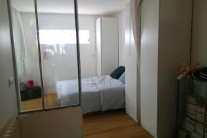 バニョレにあるQuiet and spacious 90 m loft in Bagnoletの小さなベッドルーム(ベッド1台、鏡付)