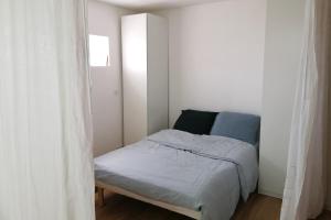 バニョレにあるQuiet and spacious 90 m loft in Bagnoletの白い部屋の小さなベッドルーム1室(ベッド1台付)