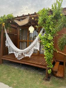 a hammock on a porch of a house at Bangalôs Flecheiras de Canaã in Flecheiras