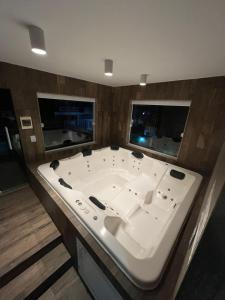 bañera grande en una habitación con 2 ventanas en Casa agradável em frente a praia com jacuzzi/spa, en Niterói