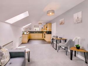 a living room and kitchen with a couch and tables at 1 Bed in Holmfirth 88554 in Holmfirth