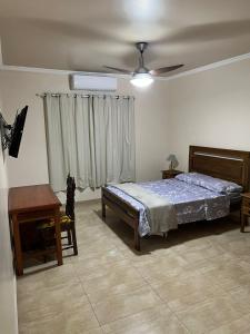 1 dormitorio con 1 cama y ventilador de techo en Casa agradável em frente a praia com jacuzzi/spa, en Niterói