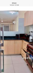 a kitchen with wooden cabinets and black counter tops at 3RD Ave. Beach Apartment Nyali, Mombasa, North Coast in Nyali