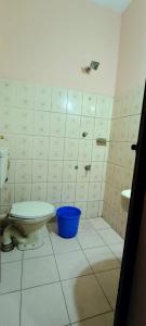 a bathroom with a toilet and a blue bucket at Classic Tourist Home in Cochin