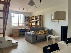 a living room with a gray couch and a desk at Lovely house in Bellaterra (10 min to UAB) in Cerdanyola del Valles