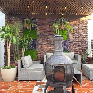 a patio with a brick wall with a fire place at Brazilian Art & Free Parking - emitimos factura in Quetzaltenango