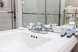 Un lavabo de baño con grifo y espejo. en Cozy Downtown Studio, #41, en Boston 7 fotos más