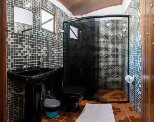 a bathroom with a black toilet and a sink at Hospedaria Diamante Lençóis in Lençóis +42 photos