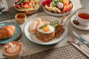 una mesa cubierta con platos de comida y tazas de café en Maison Aurelia Sanur, Bali - By Préférence, en Sanur