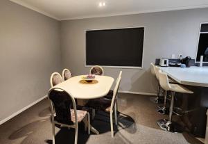 uma sala de conferências com uma mesa e cadeiras e uma televisão em A room in a homestay em Upper Hutt