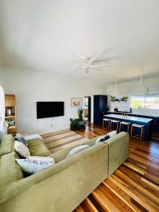 ein Wohnzimmer mit einem Sofa und einer Tischtennisplatte in der Unterkunft Absolute Beachfront Bowen Beach House-family time in Bowen