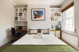 a bedroom with a bed with a green rug at London Is Yours - 2 Bedroom in Kensington in London