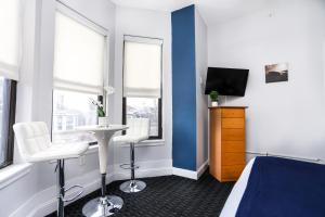 a hotel room with a bed and a table and chairs at Heart of South End, Convenient, Comfy Studio #42 in Boston