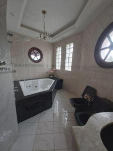 La grande salle de bains est pourvue d'une baignoire et de toilettes. dans l'établissement Castelinho do Felix Guarujá Pernambuco, à Guarujá