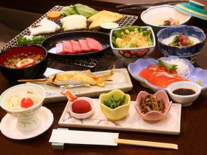 een tafel met veel verschillende gerechten op het eten bij Yunohirakan in Takayama
