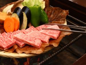 un plato de comida con carne y hortalizas en Yunohirakan, en Takayama