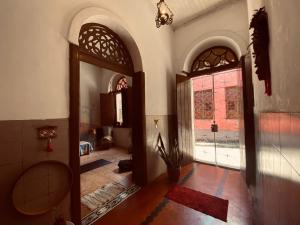 um quarto com um corredor com uma porta e janelas em Yorukàsa em São Luís