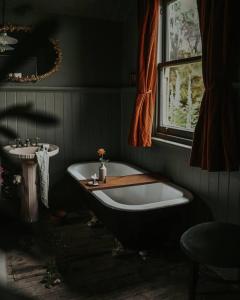 WaratahにあるThe Post Office Waratah - Luxury Wilderness Escapeのバスタブと洗面台のあるバスルーム