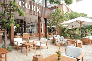 un restaurant avec des tables, des chaises et des parasols dans l'établissement Maison Aurelia Sanur, Bali - By Préférence, à anur