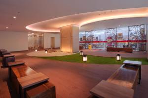 a lobby with benches and tables in a building at Citadines Gatot Subroto Jakarta in Jakarta