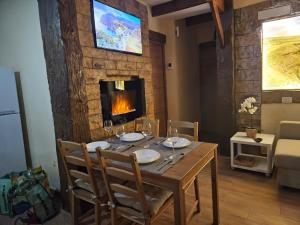 comedor con mesa y chimenea en Rustic House, en San Miguel de Abona
