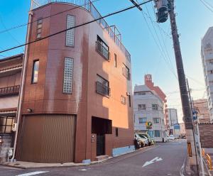 a tall brick building on a city street at Nagoya Mikiya 独栋3卧室2卫生间2浴室 名古屋站走路600m in Nagoya